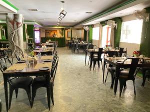 a dining room with tables and chairs in a restaurant at Hotel Green Park in Korba