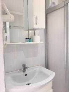ein Badezimmer mit einem weißen Waschbecken und einem Spiegel in der Unterkunft Sunset Apart Otel in Oludeniz
