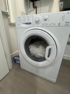 a white washing machine sitting in a room at East London penthouse views 2bd in Barking