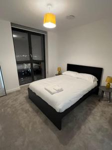 a bedroom with a large bed and a large window at East London penthouse views 2bd in Barking