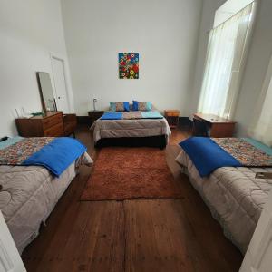 a bedroom with two beds and a rug at Casa en casco Historico Portal Del Valle in La Serena