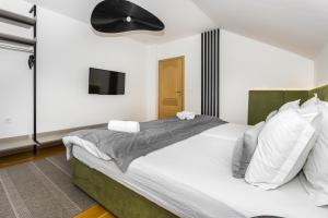 ein Schlafzimmer mit einem großen Bett und einem Flachbild-TV in der Unterkunft Art of Living luxury suite three in Sarajevo