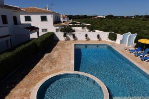 a swimming pool in front of a house at Mira Parque in Albufeira