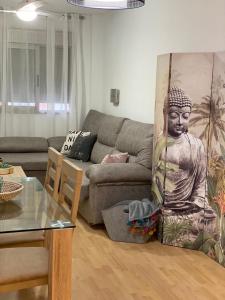 una sala de estar con sofá y un gran mural de una estatua en Precioso apartamento en zona de playa, en Almería