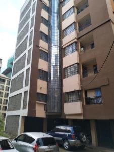 Un grand bâtiment avec des voitures garées devant lui dans l'établissement 1 bedroom TRM drive Roysambu Thika road, à Nairobi