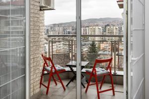 2 Stühle und ein Tisch auf einem Balkon mit Aussicht in der Unterkunft Art of Living luxury suite three in Sarajevo