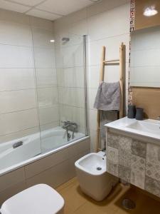 y baño con bañera, aseo y lavamanos. en Precioso apartamento en zona de playa, en Almería