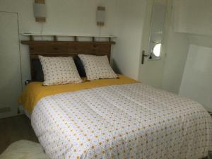 a bedroom with a bed with a yellow and white comforter at Péniche GEMJO in Castelsarrasin