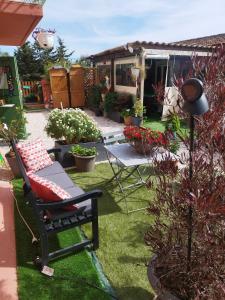 a garden with a bench and a table and some plants at Le petit atelier in Bormes-les-Mimosas