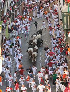 una gran multitud de personas caminando por una calle en Pamplona ciudad maravilla en Pamplona