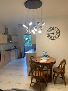 a kitchen with a table and chairs and a clock at Great family-friendly Appartment flic en flac MRU in Flic-en-Flac
