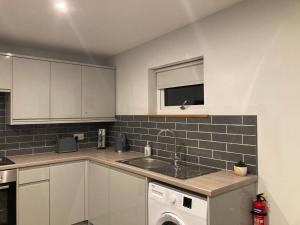 a kitchen with a sink and a washing machine at North Coast Escapes in Thrumster