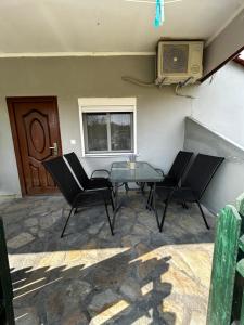 patio con mesa, sillas y ventana en Maison de roche, en Sozopoli