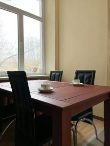 a dining room table with chairs and a large window at Hostel Kornealita in Zarasai