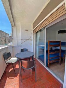 balkon ze stołem, krzesłami i łóżkiem w obiekcie Palermo Soho Hostel w BuenosAires