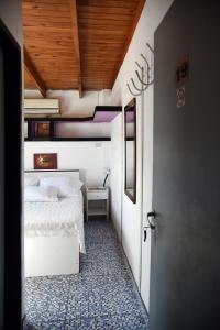 Palermo Soho Hostel في بوينس آيرس: غرفة نوم بسرير ابيض وسقف خشبي