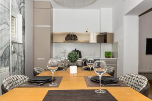a dining room table with chairs and wine glasses at Art of Living Luxury suite one in Sarajevo