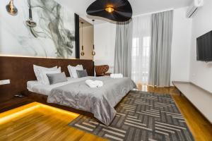 a bedroom with a large bed and a television at Art of Living Luxury suite one in Sarajevo