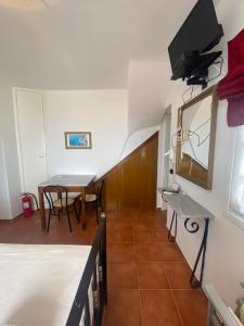 a room with a table and a tv on the wall at AEOLOS Apartments in Akrotiri