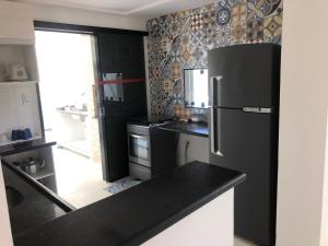 een zwart-witte keuken met een koelkast bij Casa Aruana in Aracaju