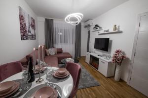 een woonkamer met een eettafel en een bank bij Apartman Neda N in Vrnjačka Banja