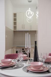een eettafel met roze borden en wijnglazen bij Apartman Neda N in Vrnjačka Banja