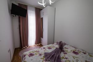 een slaapkamer met een bed met een dekbed erop bij Apartman Neda N in Vrnjačka Banja