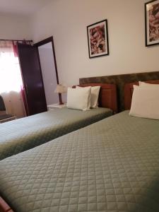 Habitación de hotel con 2 camas y espejo en Casa Vaz 2 en Grândola