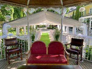 a porch with two chairs and a gazebo at Hotelik Polonia in Łowicz