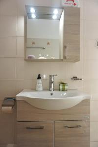 a bathroom with a white sink and a mirror at Villa Elizabeth Athos in Ouranoupoli