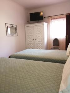 1 dormitorio con 2 camas y vestidor con TV en Casa Vaz 2 en Grândola