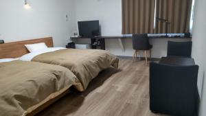 sypialnia z 2 łóżkami, biurkiem i 2 krzesłami w obiekcie Basic Hotel Chichibu w mieście Chichibu