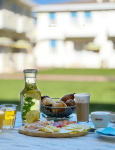 einen Tisch mit einem Teller Essen und einer Flasche Saft in der Unterkunft Junior Depandance in Cavallino-Treporti