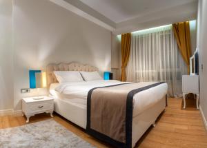 a bedroom with a large white bed and a television at Armoni Residence Istanbul in Istanbul