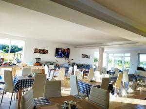 ein Esszimmer mit Tischen und weißen Stühlen in der Unterkunft Kajaki i Rowery in Ruciane-Nida