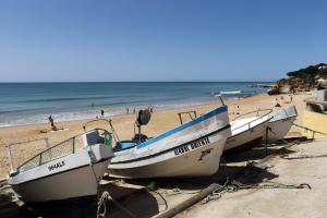 three boats on a beach with people on the beach at Mira Parque in Albufeira