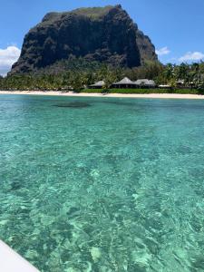 a view of a beach with a mountain in the background at Résidence au bout du Morne in Le Morne