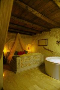 ein Schlafzimmer mit einer Badewanne und einem Bett in einem Zimmer in der Unterkunft Nova Cave Hotel in Ortahisar