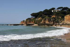 a beach with a house on top of a mountain at Mira Parque in Albufeira