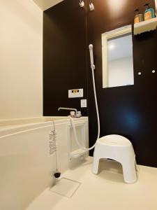 uma casa de banho com um WC branco e um espelho. em Lucky you! YOTSUYA em Tóquio