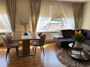 sala de estar con mesa y sofá en Upes apartamenti Nr: 32, en Valmiera