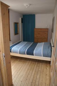 um quarto com uma cama e piso em madeira em Ostend Zen em Oostende