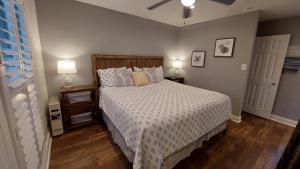 1 dormitorio con 1 cama con edredón blanco y 2 lámparas en Bay Tree B3, en Port Aransas