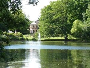 a pond with a fountain in front of a house at Lessing-Apartment in Düsseldorf