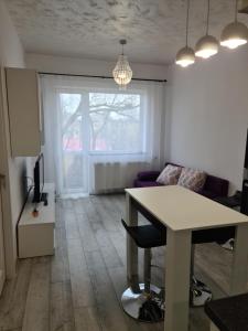 a living room with a table and a couch at APARTAMENT IN CENTRU in Oradea