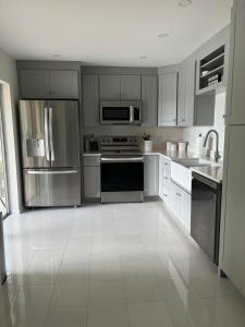 a kitchen with stainless steel appliances and white tile floors at Great location with lake view in Naples