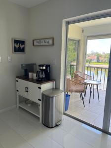 a kitchen with a coffee maker and a balcony at Great location with lake view in Naples
