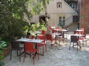 a group of tables and chairs in a courtyard at Logis Hotel Restaurant Le Cheval Blanc in Charny