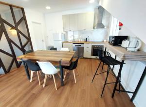uma cozinha com uma mesa de madeira e cadeiras em Ritta´s House - Covilhã na Covilhã