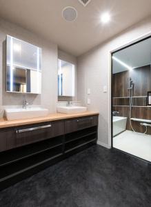 łazienka z 2 umywalkami i dużym lustrem w obiekcie Hotel Legit w mieście Hiroszima